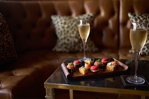 A couple of champagne flutes on a table within the Leopard Room at The Rubens at the Palace